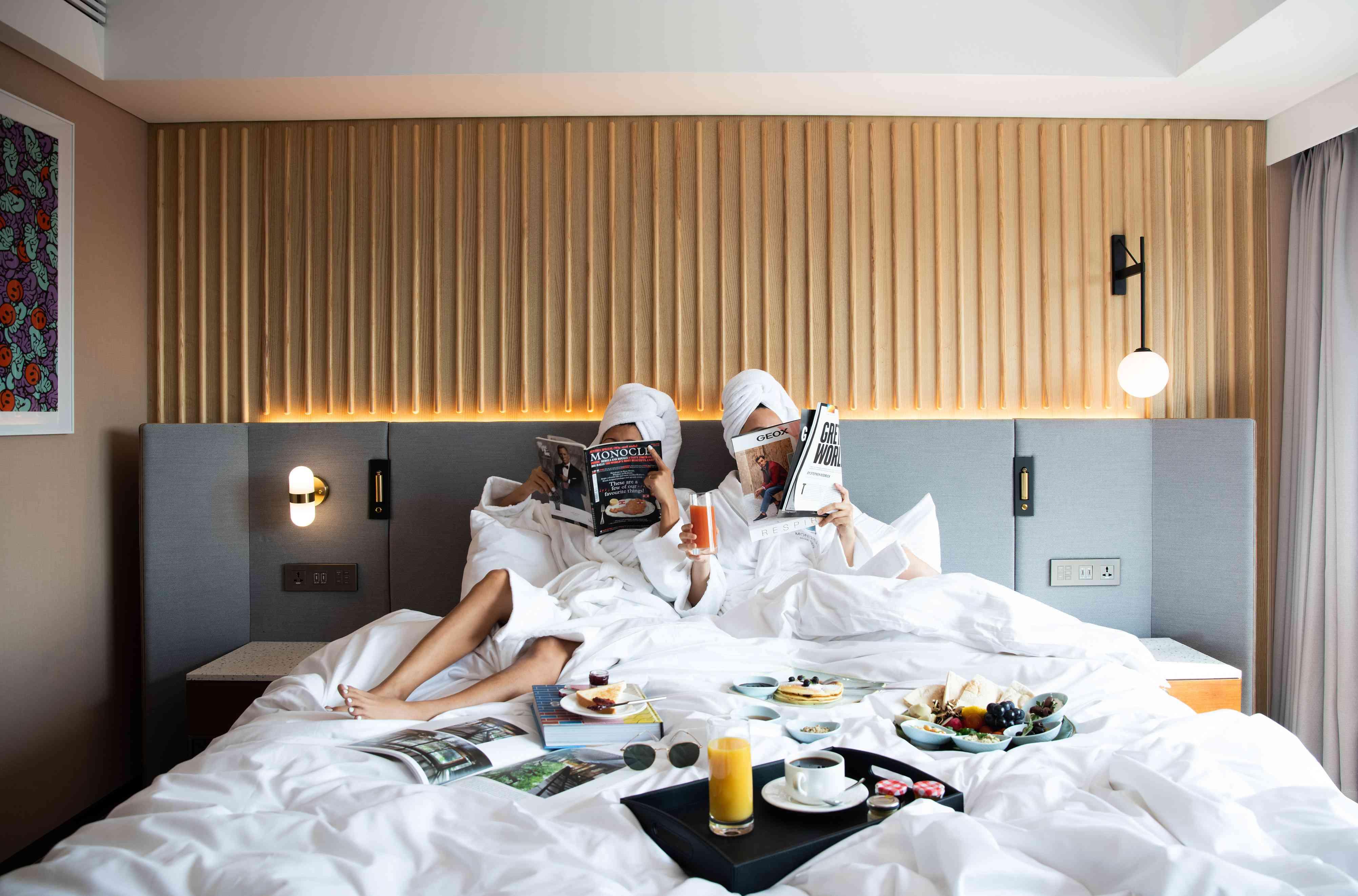 personnes sur lit d'hôtel avec petit déjeuner