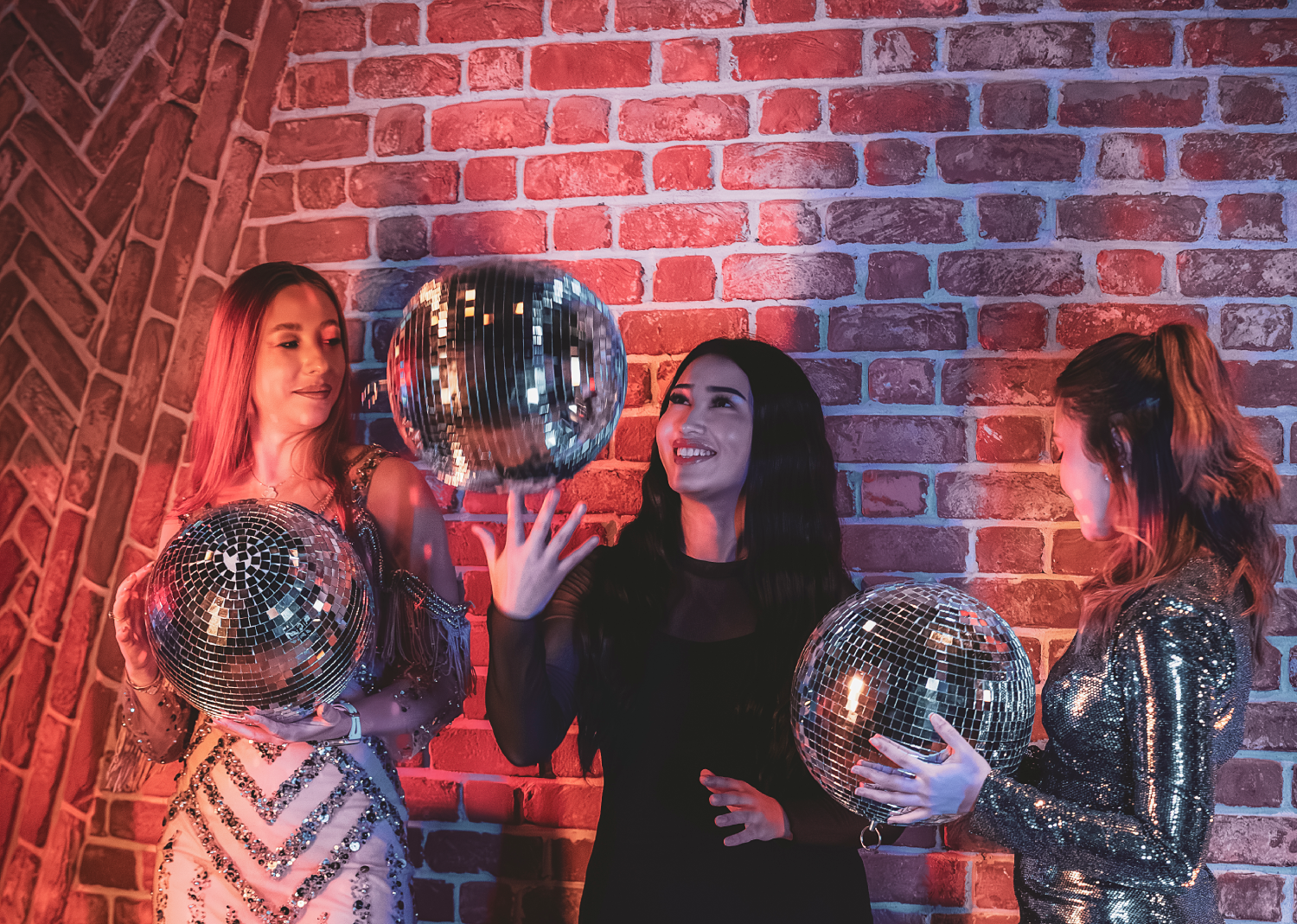 Trois femmes tenant chacune une boule disco 