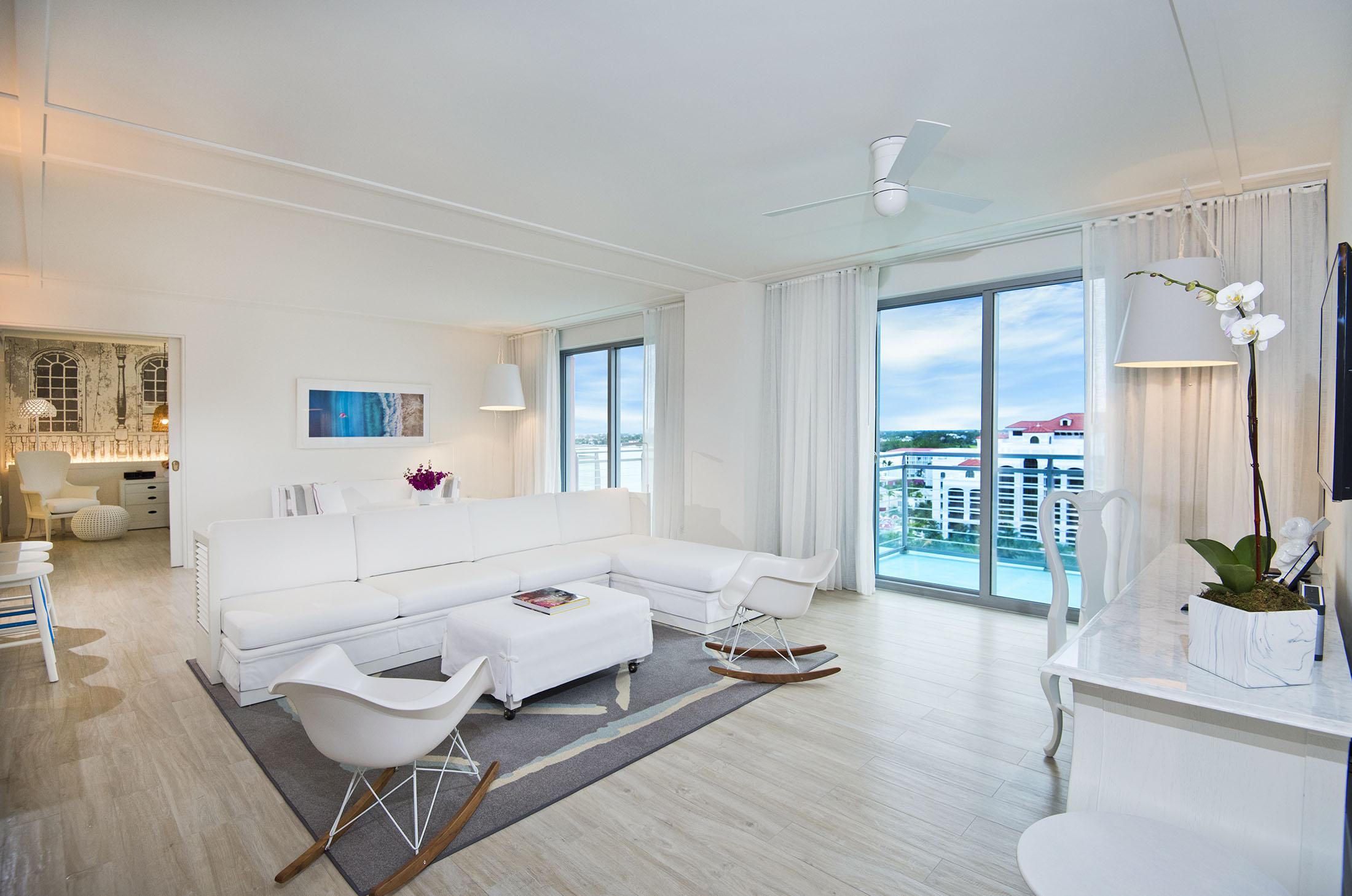 espace de vie de chambre d'hôtel avec canapé blanc et chaises