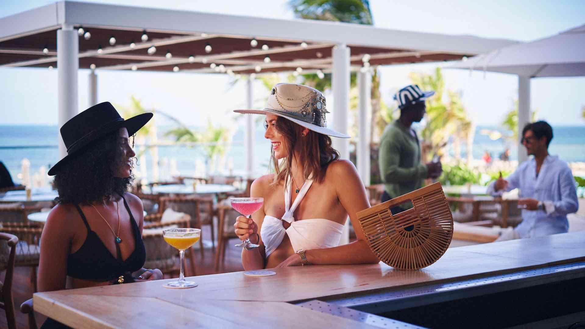Femmes assises au bar extérieur avec des cocktails