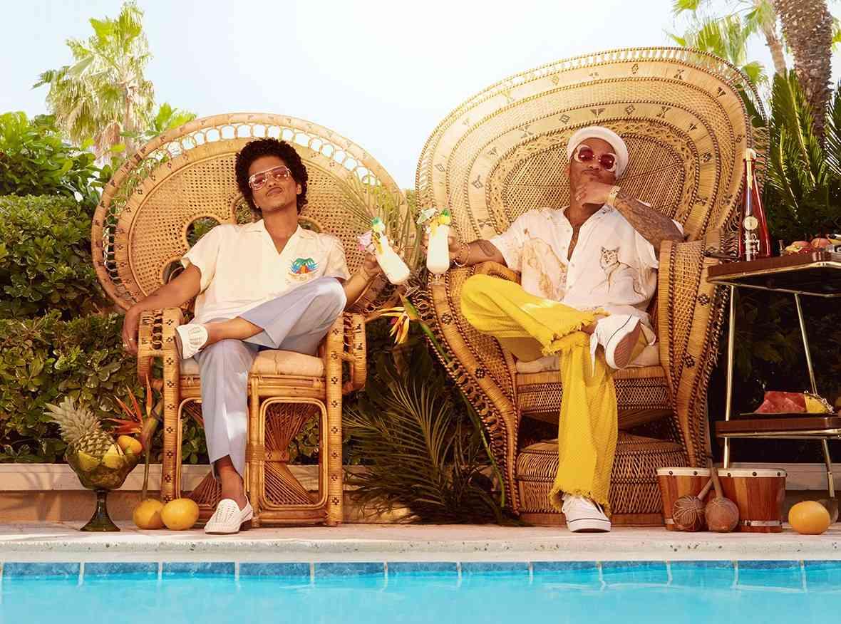 Bruno Mars et Anderson Paak assis sur des chaises au bord d'une piscine 