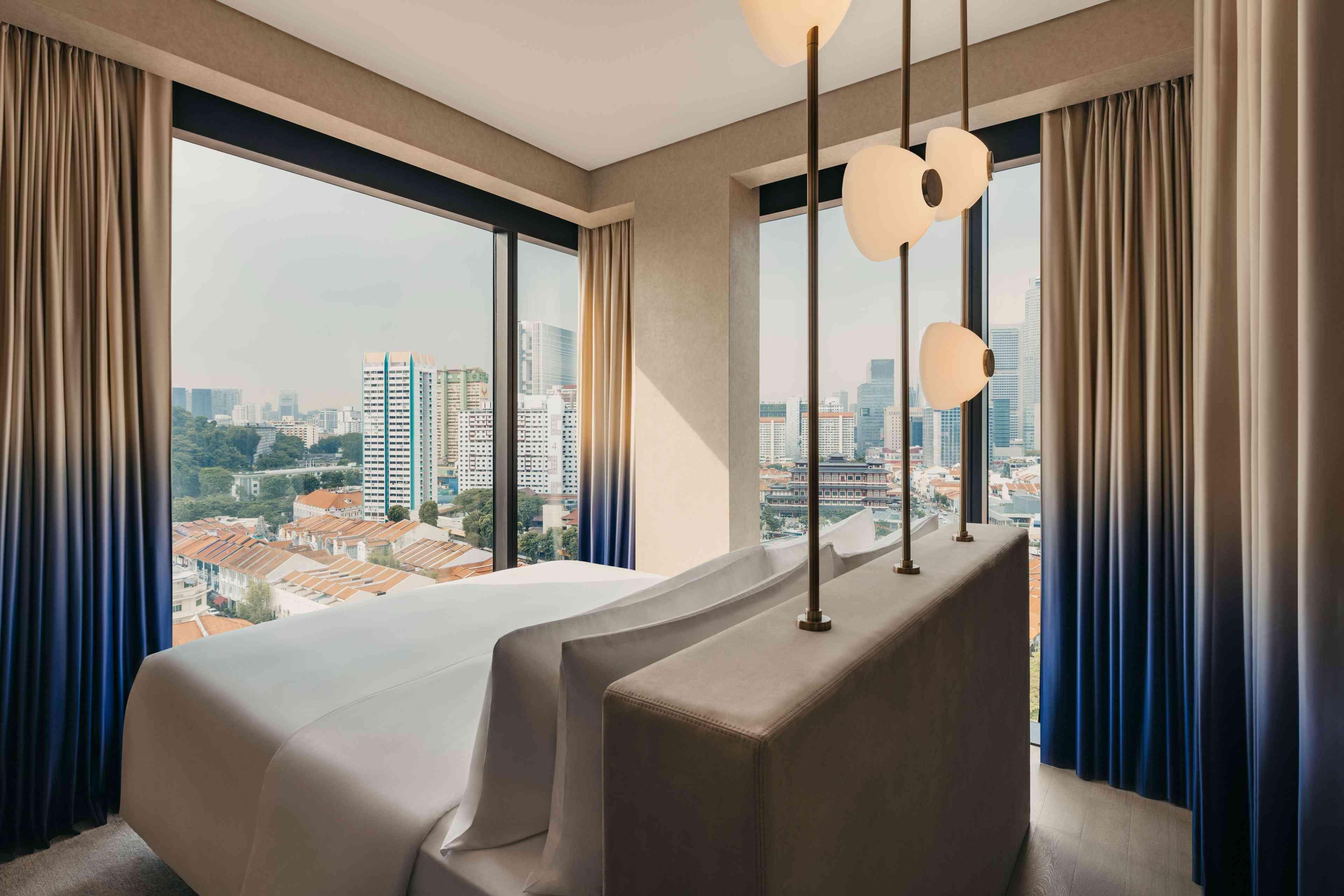 Suite du Mondrian Singapore Duxton avec baies vitrées donnant sur la ville. 