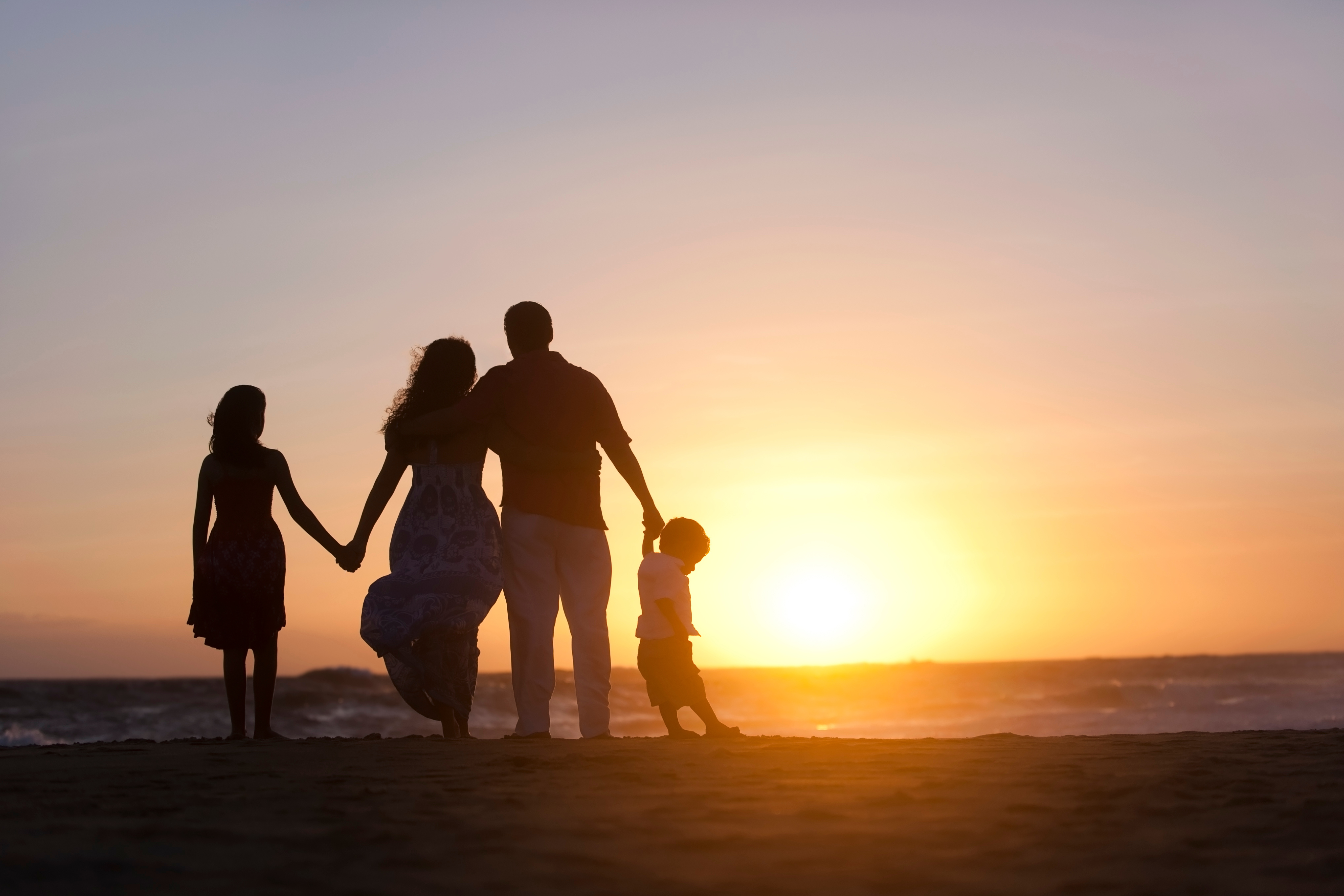 Famille sur la plage pendant un coucher de soleil